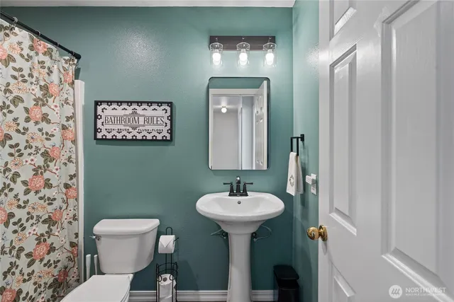 a bathroom with a toilet sink and mirror
