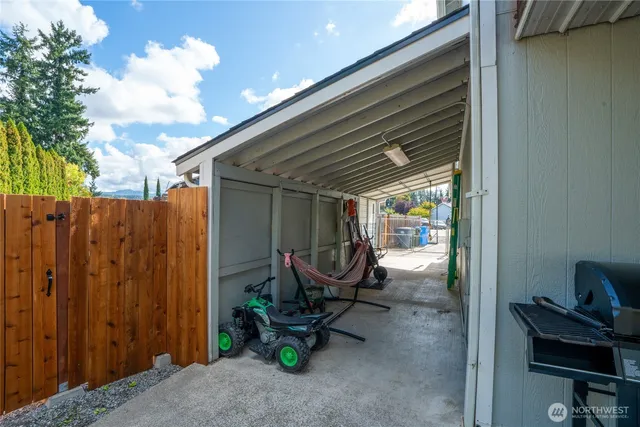 a view of a chair and table in backyard of the house