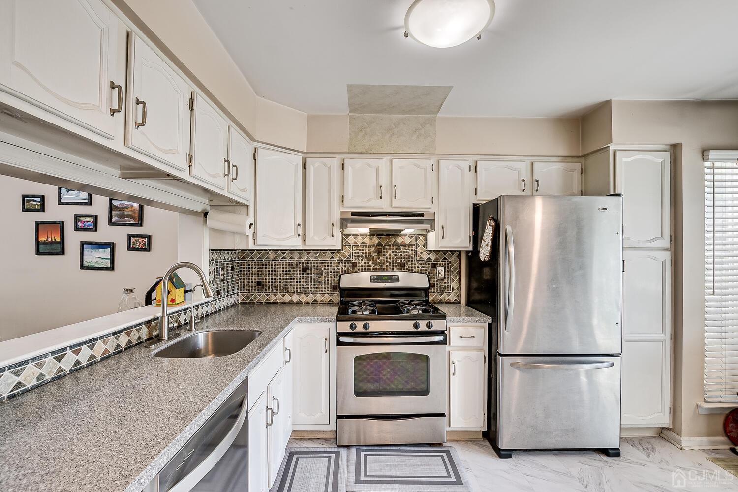 1005 Maplecrest Road Edison, NJ 08820 - Photo 14 of 48 a kitchen with stainless steel appliances a refrigerator sink and cabinets