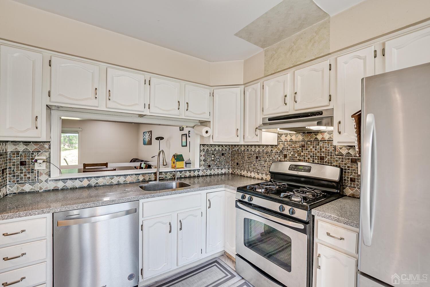 1005 Maplecrest Road Edison, NJ 08820 - Photo 17 of 48 a kitchen with stainless steel appliances granite countertop a stove a refrigerator and a white cabinets