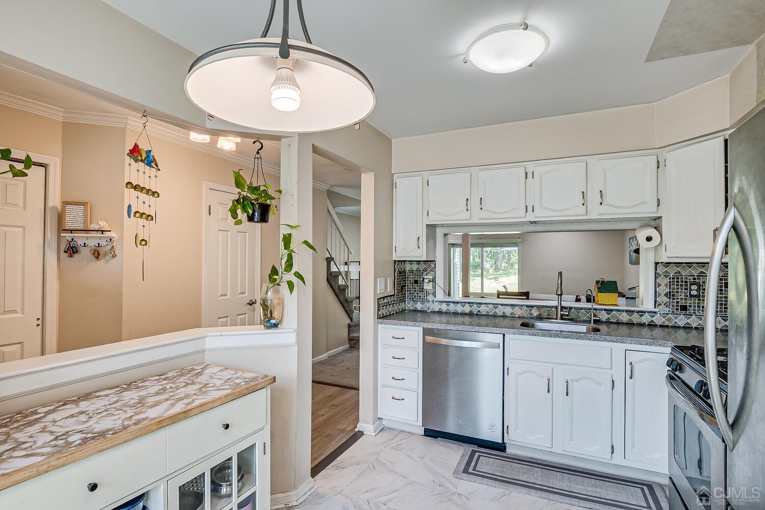 1005 Maplecrest Road Edison, NJ 08820 - Photo 19 of 48 a kitchen with white cabinets and appliances