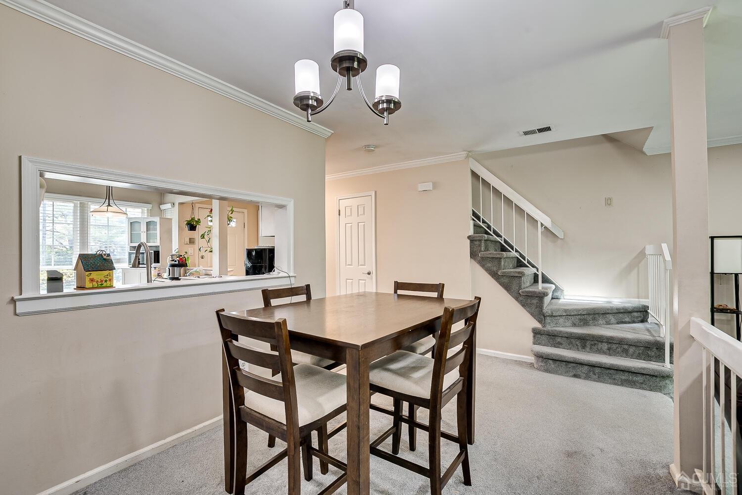 1005 Maplecrest Road Edison, NJ 08820 - Photo 22 of 48 a dining room with wooden floor a chandelier a wooden table and chairs