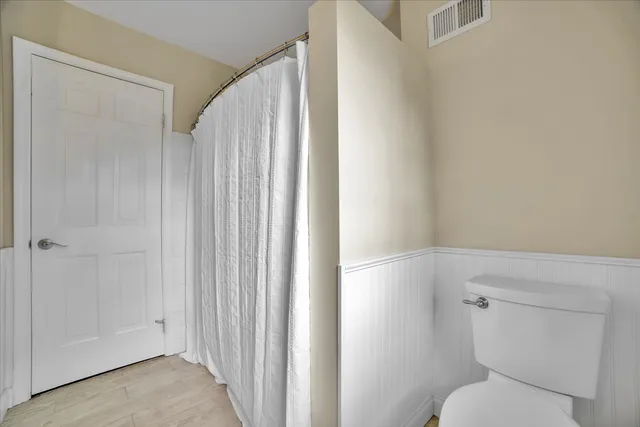 a bathroom with a toilet and a shower curtain
