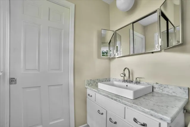a bathroom with a granite countertop sink and a mirror