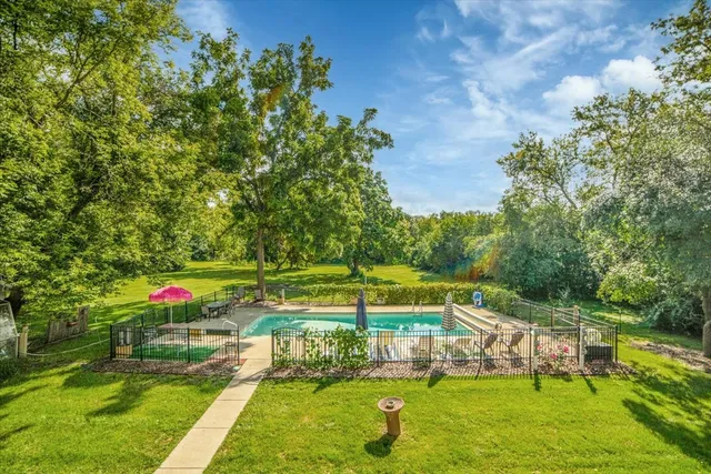 a view of yard with swimming pool and green space
