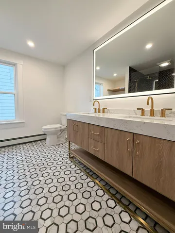 a bathroom with a toilet a sink and a mirror