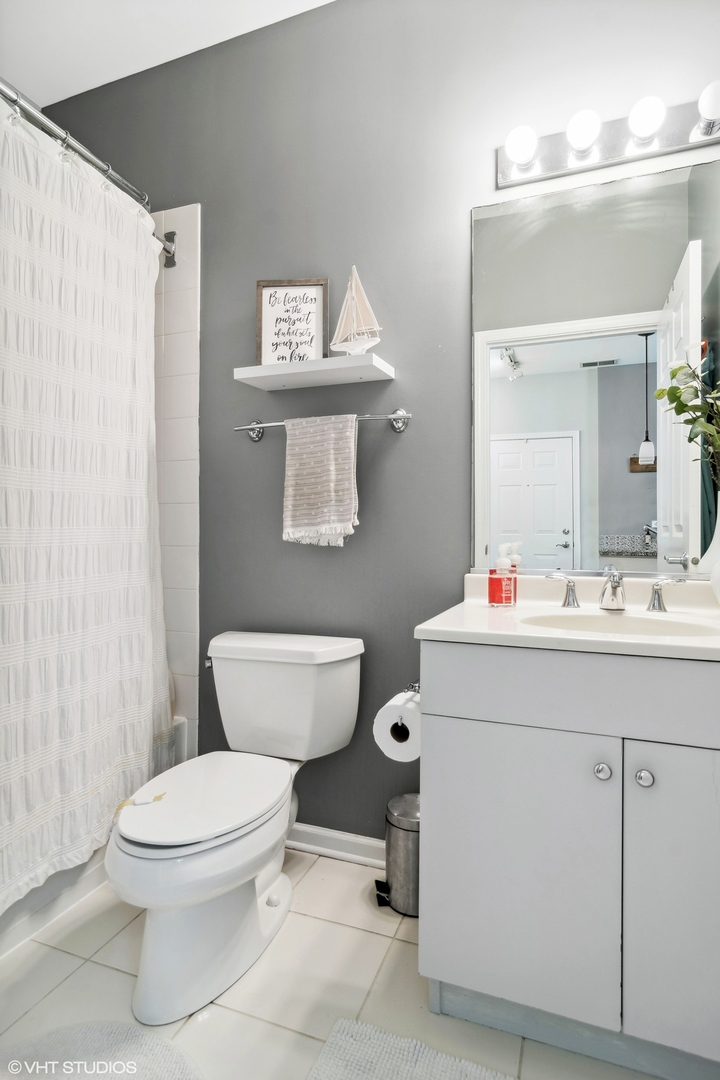 1451 South Halsted Street, Unit 2A Chicago, IL 60607 - Photo 9 of 10 a bathroom with a toilet sink and mirror