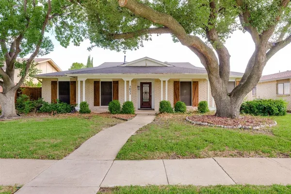 a front view of a house with yard and green space