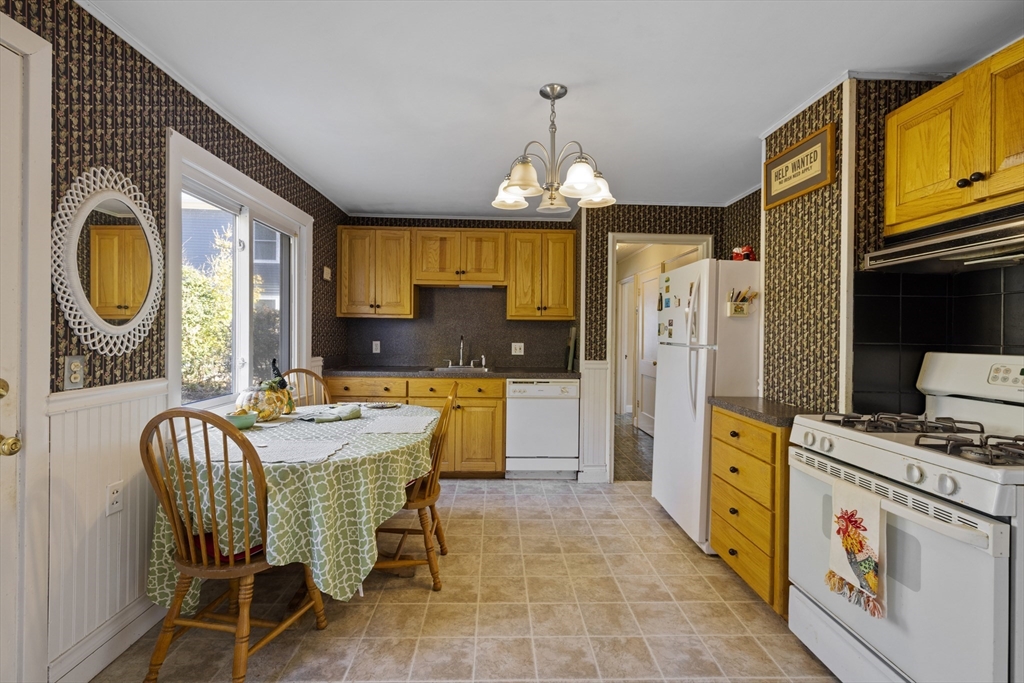 51 Appleton Street Saugus, MA 01906 - Photo 5 of 17 a kitchen with stainless steel appliances granite countertop a stove a refrigerator a kitchen island a dining table and chairs