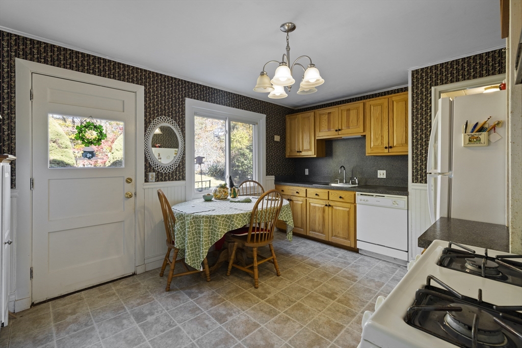51 Appleton Street Saugus, MA 01906 - Photo 6 of 17 a kitchen with a refrigerator a stove a sink and dining table with wooden floor
