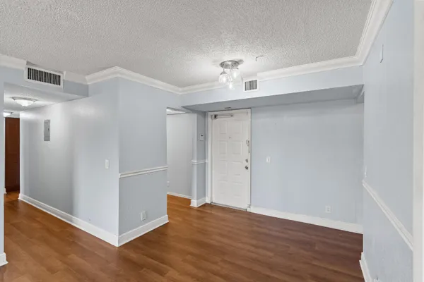 a kitchen with stainless steel appliances granite countertop a refrigerator a sink dishwasher a stove and white countertops with wooden floor