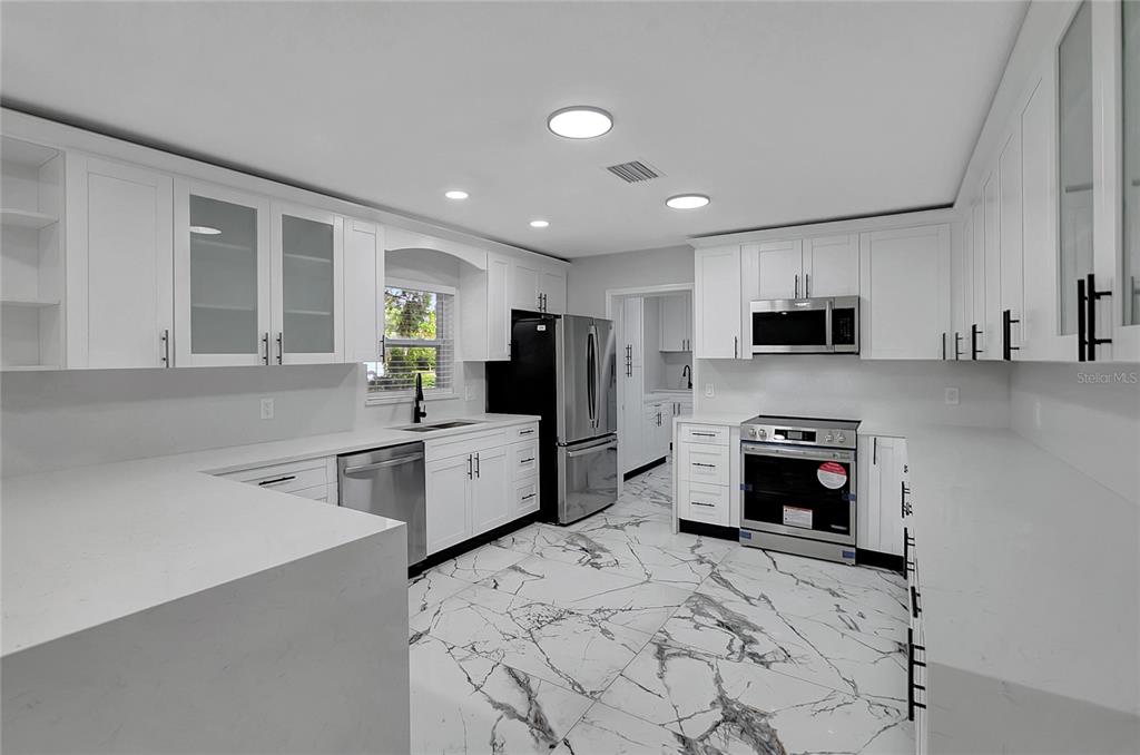 604 Druid Hills Road Temple Terrace, FL 33617 - Photo 18 of 59 a kitchen with stainless steel appliances a stove sink microwave and refrigerator