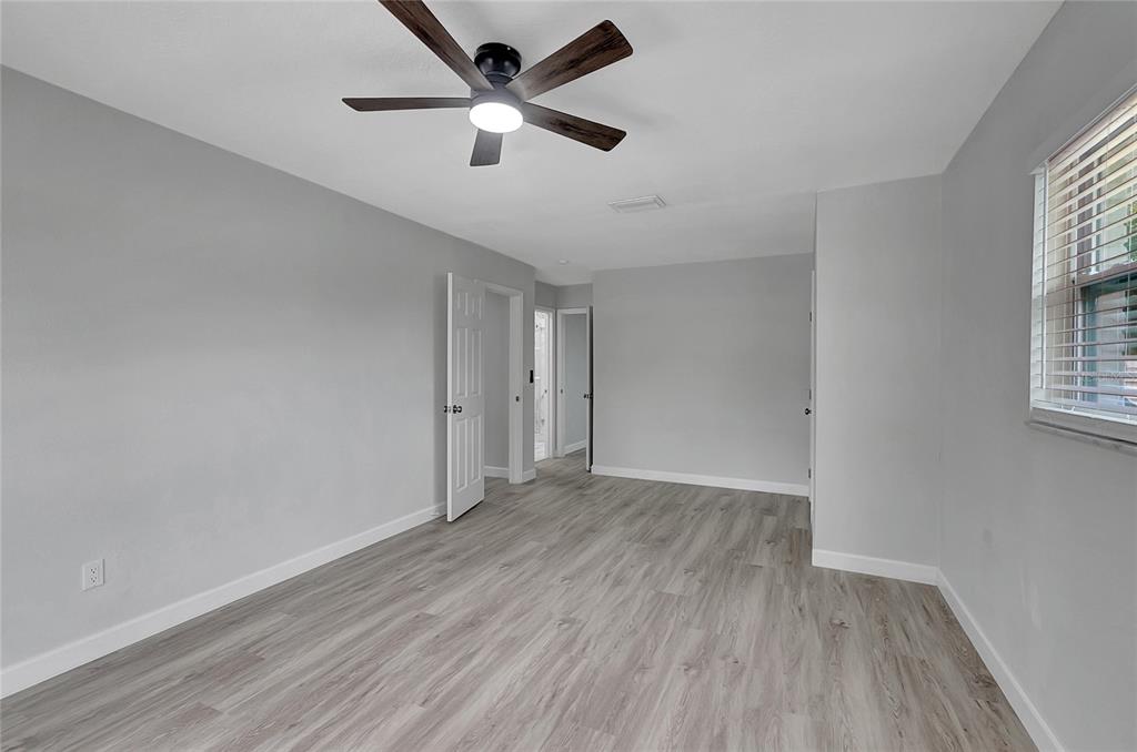 604 Druid Hills Road Temple Terrace, FL 33617 - Photo 33 of 59 an empty room with wooden floor and windows
