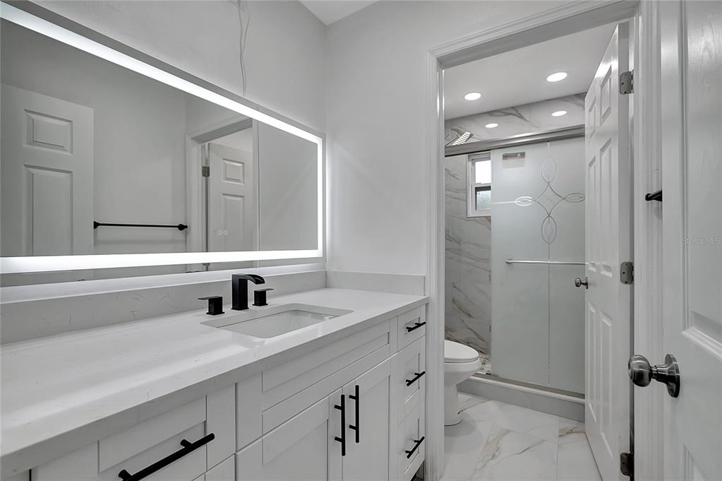 604 Druid Hills Road Temple Terrace, FL 33617 - Photo 44 of 59 a bathroom with a double vanity sink toilet mirror and shower