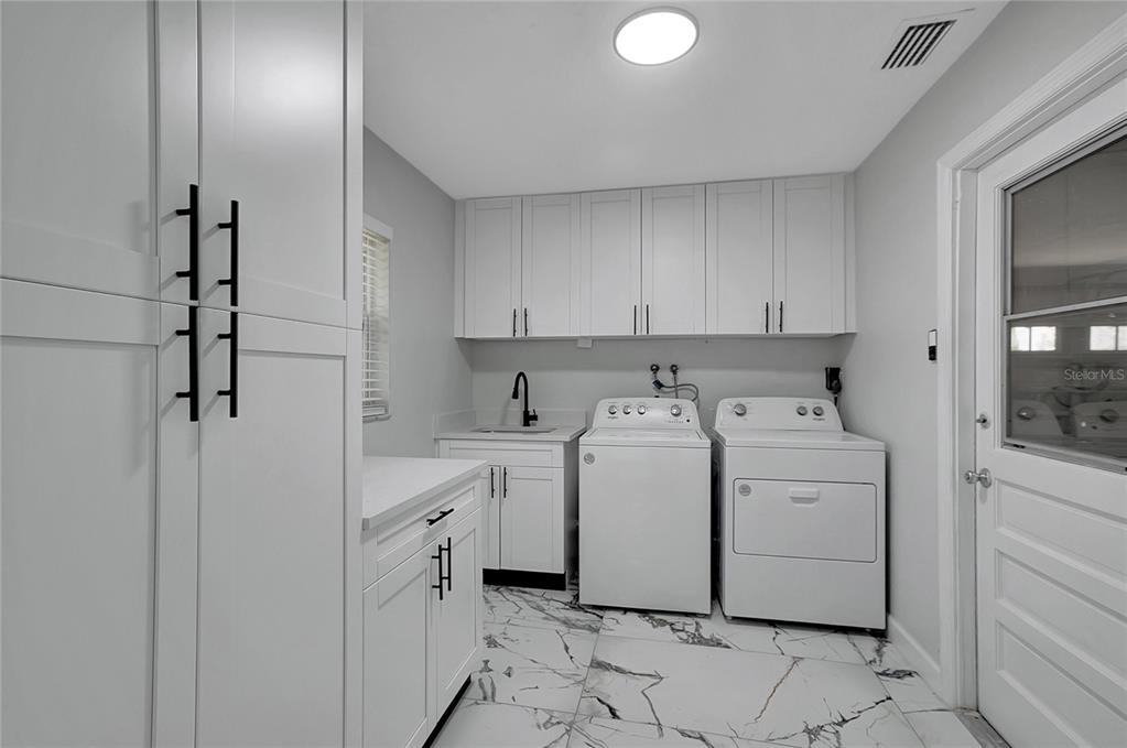 604 Druid Hills Road Temple Terrace, FL 33617 - Photo 48 of 59 a utility room with cabinets washer and dryer