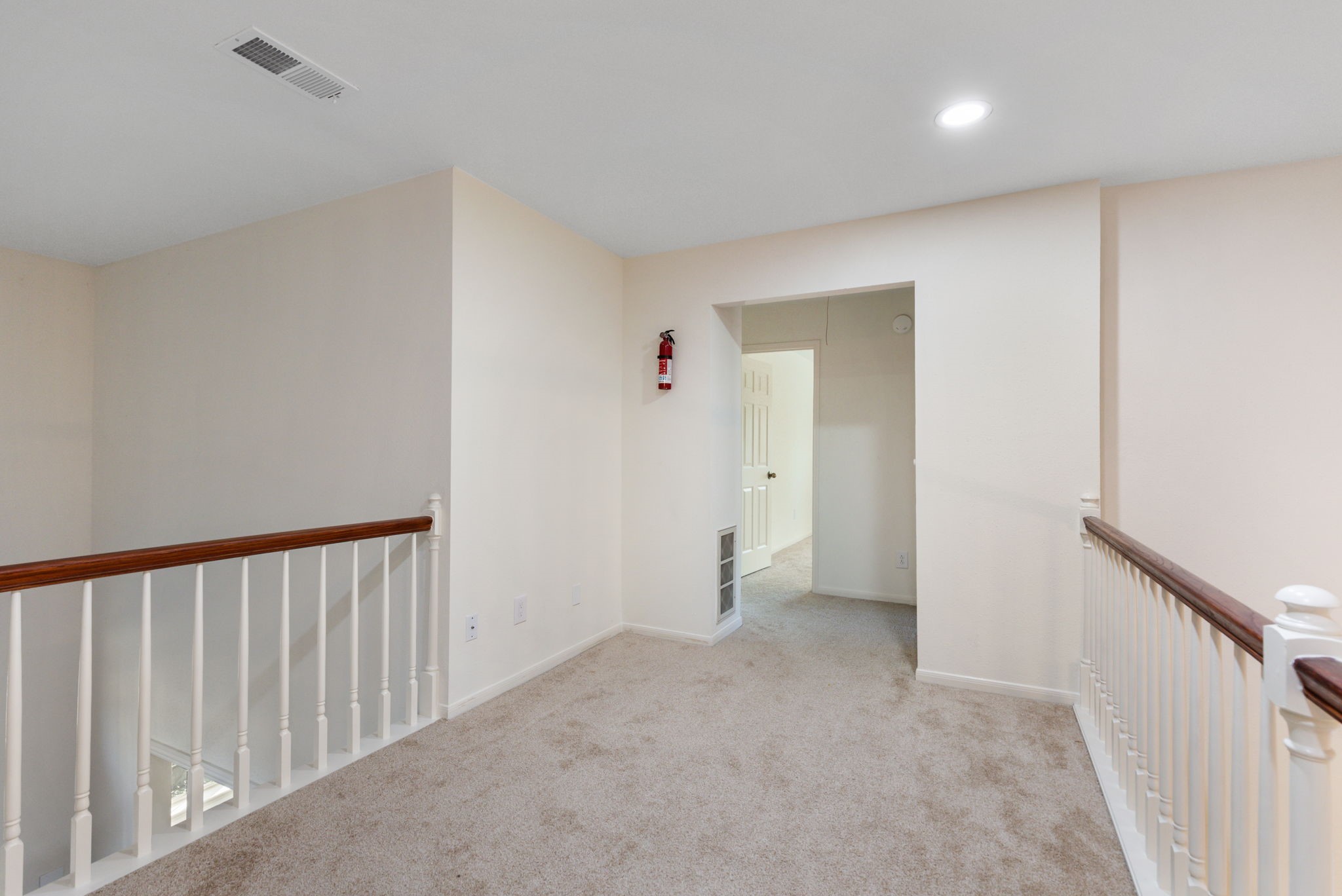 59 Fire Flicker Place Spring, TX 77381 - Photo 24 of 37 Bright upstairs hallway with recessed lighting, offering a clean and inviting space.