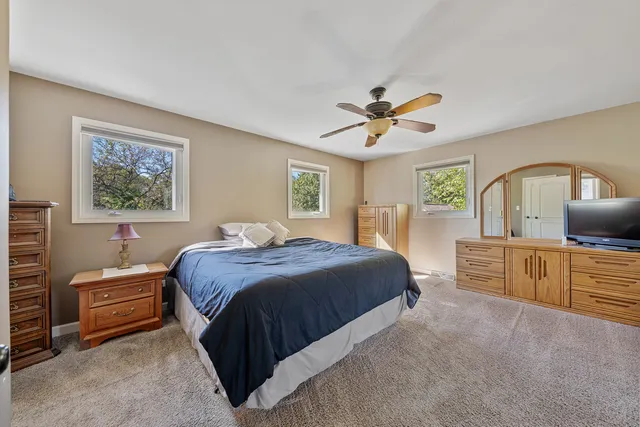 a spacious bedroom with a large bed and a chandelier