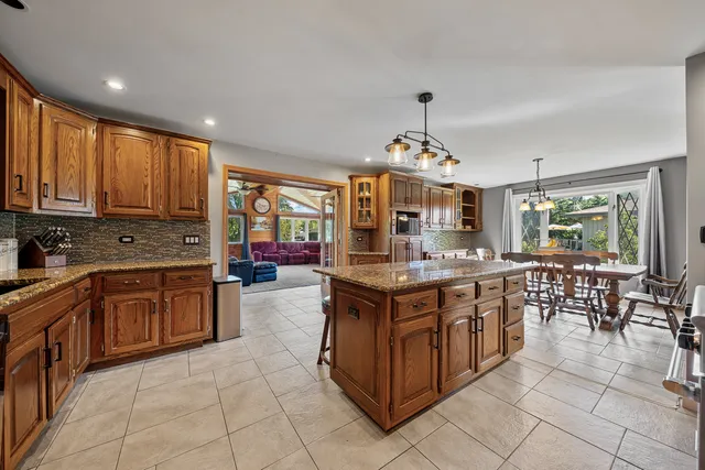 a kitchen with stainless steel appliances granite countertop wooden cabinets a stove and a sink