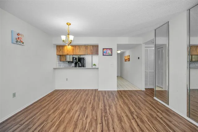 a view of a room with wooden floor a ceiling fan and a window