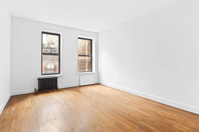 a bedroom with a bed lamp and a window