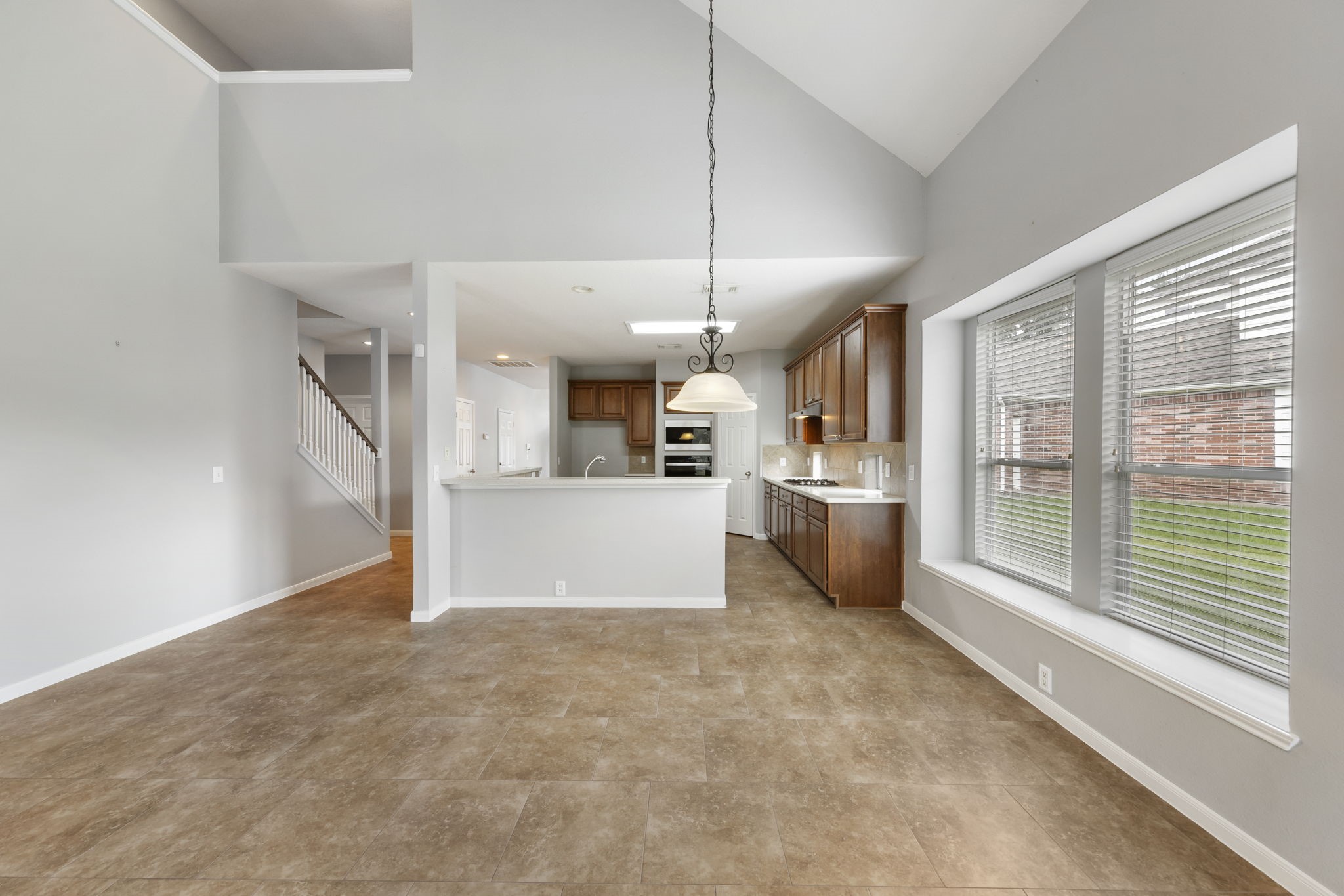 2907 Stemwood Drive Spring, TX 77388 - Photo 10 of 33 Bright and spacious living and breakfast area featuring soaring ceilings, expansive windows, and an open-concept layout that seamlessly connects to the kitchen—perfect for everyday living and entertaining.