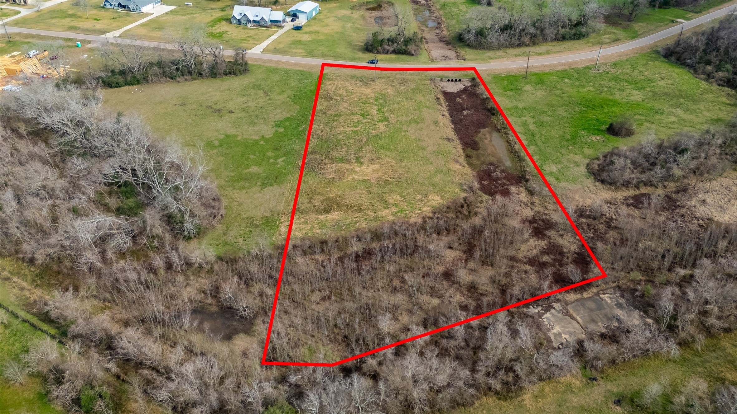 22802 Pittman Drive Angleton, TX 77515 - Photo 3 of 9 Full property perspective highlighting the depth of the homesite, open pasture, and natural wooded buffer along the rear.