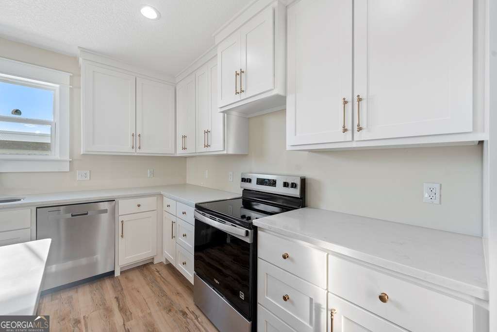 1335 Clifford Loop Blackshear, GA 31516 - Photo 22 of 43 a kitchen with granite countertop white cabinets and white appliances