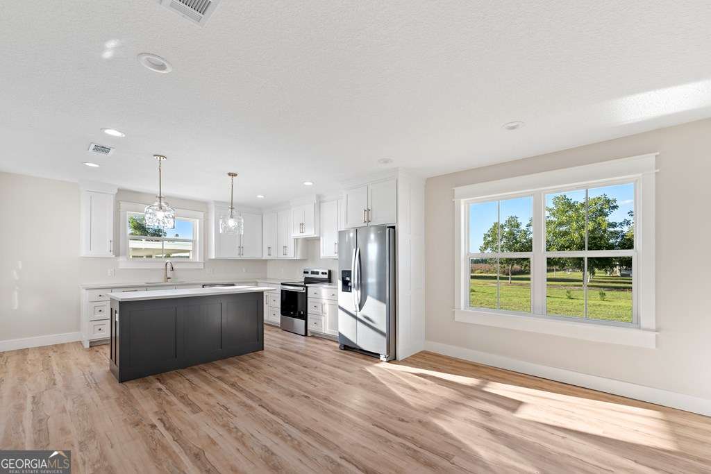 1335 Clifford Loop Blackshear, GA 31516 - Photo 23 of 43 a view of kitchen with wooden floor and window