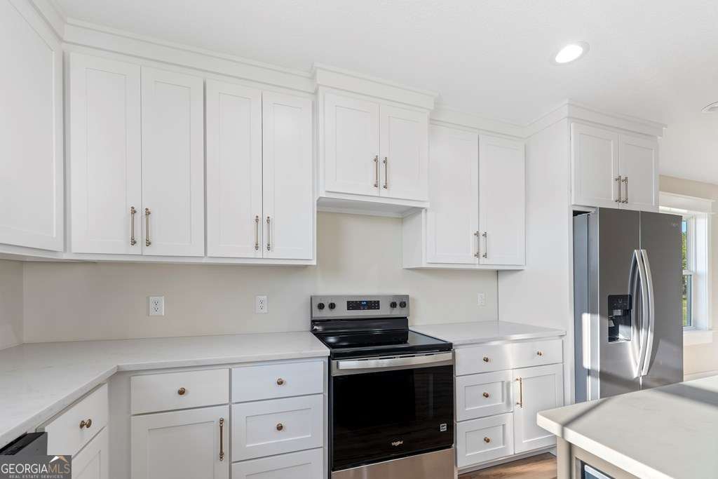 1335 Clifford Loop Blackshear, GA 31516 - Photo 25 of 43 a kitchen with white cabinets and refrigerator