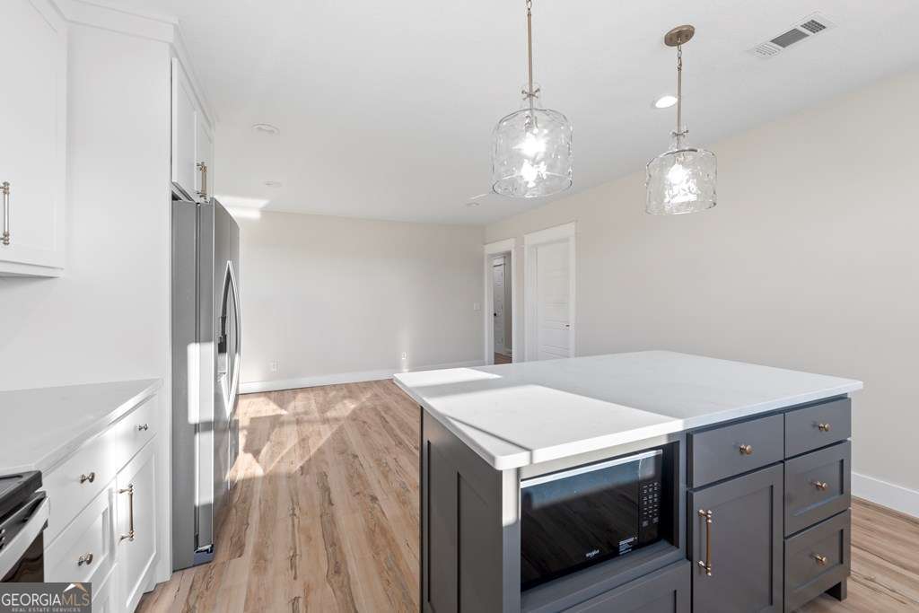 1335 Clifford Loop Blackshear, GA 31516 - Photo 26 of 43 a kitchen with a stove and a chandelier
