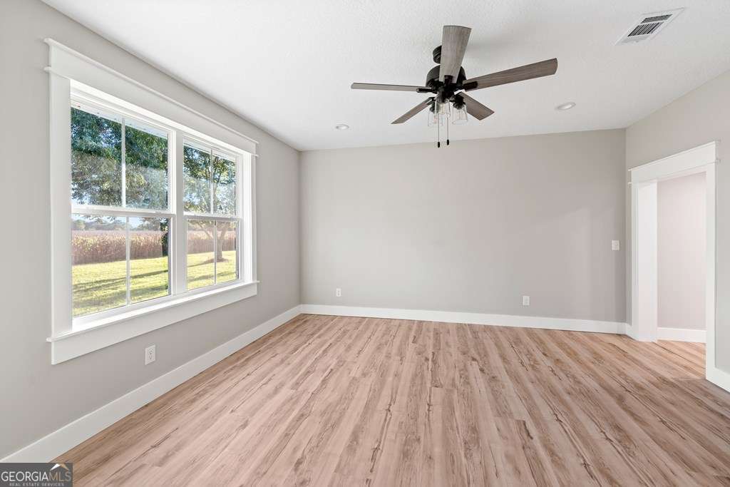 1335 Clifford Loop Blackshear, GA 31516 - Photo 34 of 43 wooden floor in an empty room with a window