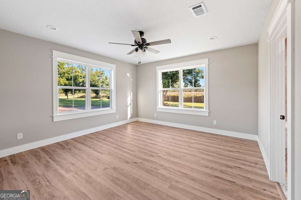 1335 Clifford Loop Blackshear, GA 31516 - Photo 35 of 43 wooden floor in an empty room with a window