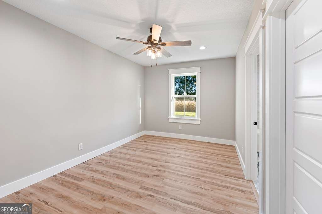 1335 Clifford Loop Blackshear, GA 31516 - Photo 36 of 43 a view of an empty room with a window and wooden floor