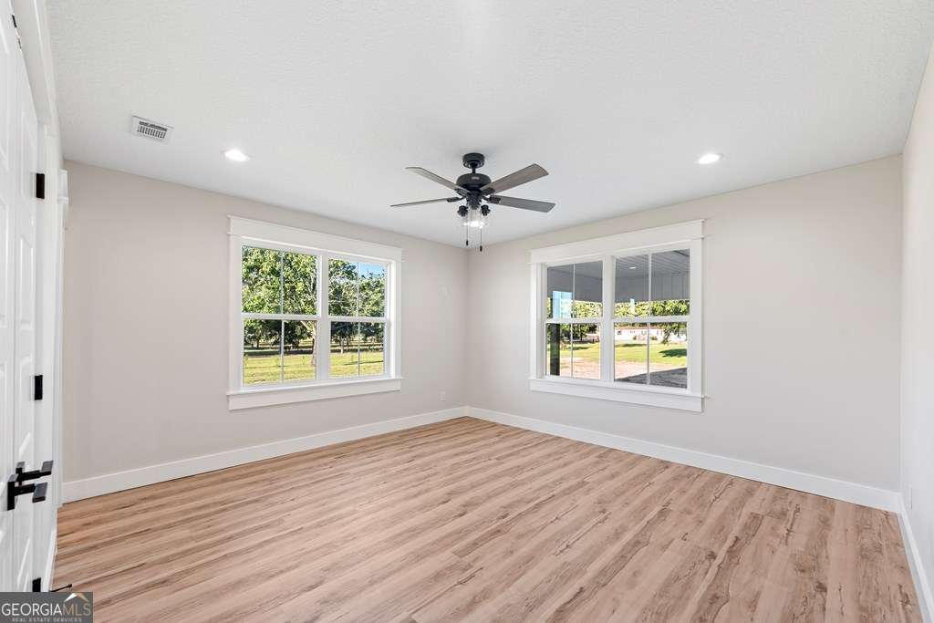 1335 Clifford Loop Blackshear, GA 31516 - Photo 38 of 43 a view of an empty room with a window and wooden floor