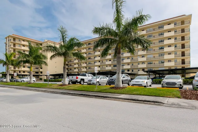 front view of a building with palm trees