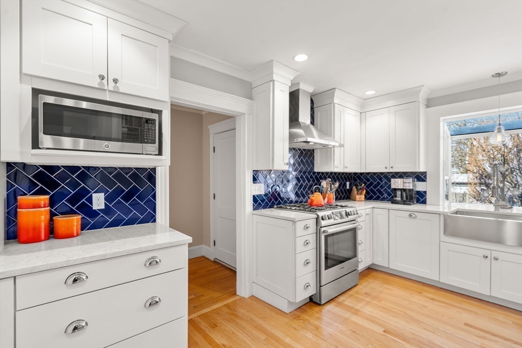 23 Newman Way, Unit 1 Arlington, MA 02476 - Photo 9 of 28 a kitchen with stainless steel appliances white cabinets and wooden floor