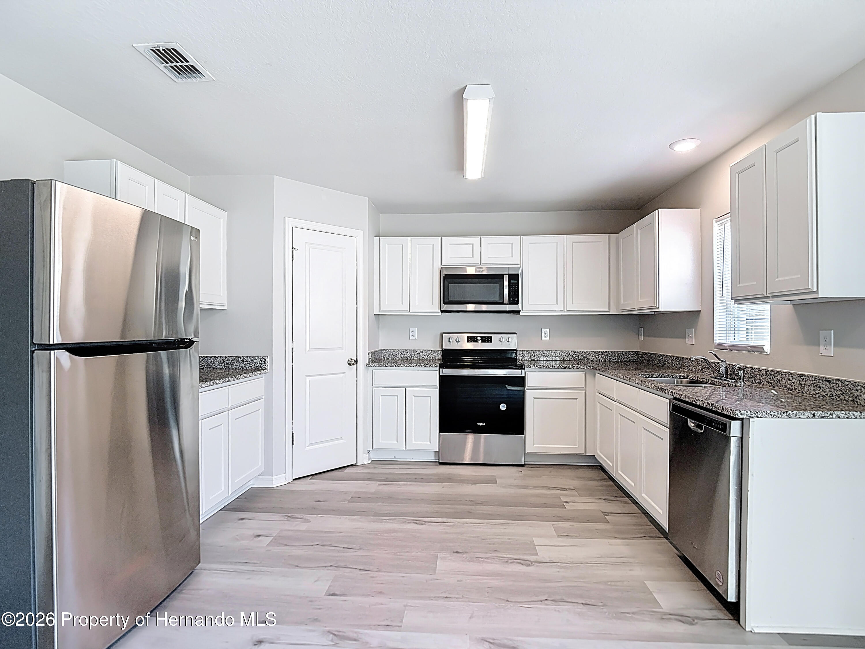 11374 Marcella Avenue Weeki Wachee, FL 34614 - Photo 22 of 70 a kitchen with stainless steel appliances granite countertop a refrigerator stove and microwave