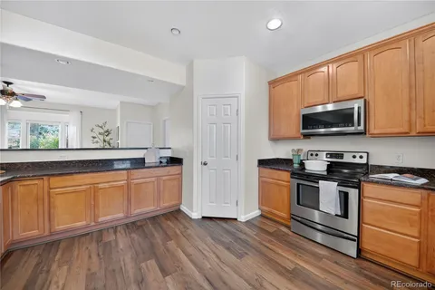 a kitchen with stainless steel appliances granite countertop wooden cabinets and a stove top oven