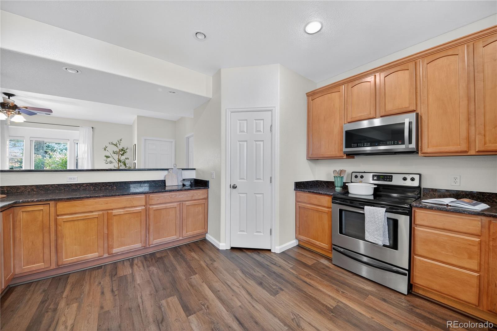665 Kilmer Street Golden, CO 80401 - Photo 16 of 35 a kitchen with stainless steel appliances granite countertop wooden cabinets and a stove top oven