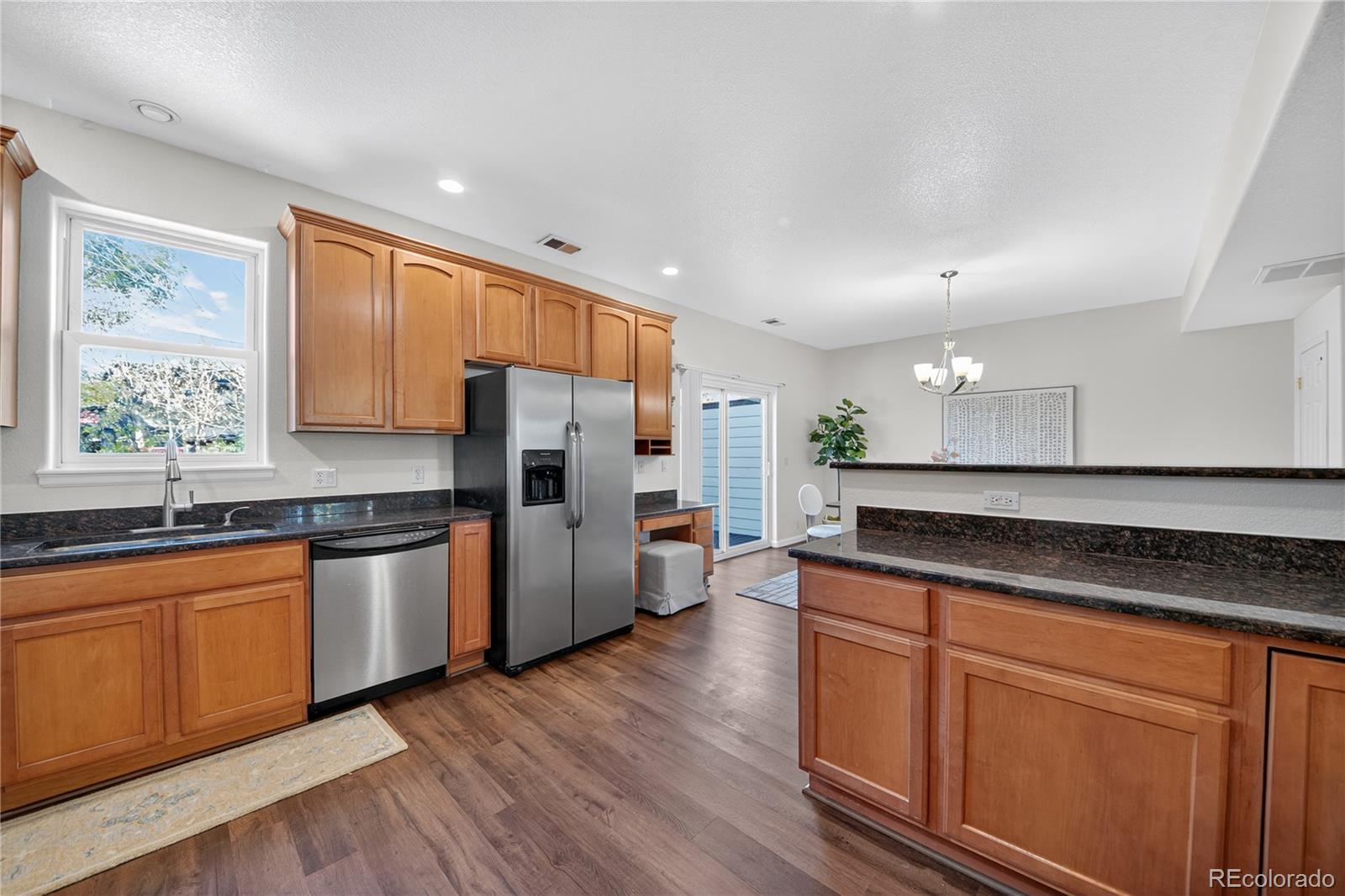 665 Kilmer Street Golden, CO 80401 - Photo 17 of 35 a kitchen with stainless steel appliances granite countertop a refrigerator a sink dishwasher a stove and white countertops with wooden floor