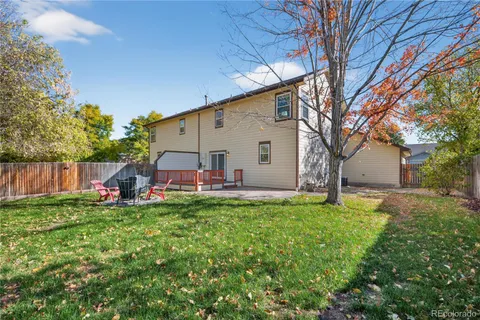 a view of a house with backyard and a tree