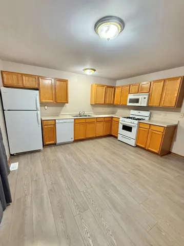 a large white kitchen with wooden floors