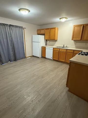 a view of kitchen with stainless steel appliances wooden floor and electronic appliances