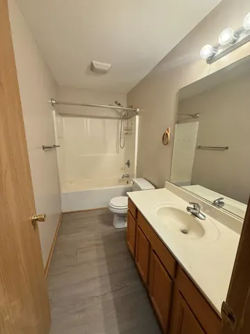a bathroom with a sink a toilet a mirror and shower