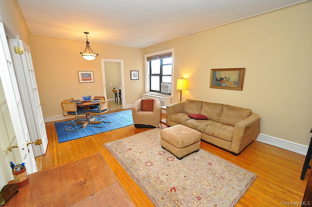 143 Garth Road, Unit 5J Scarsdale, NY 10583 - Photo 9 of 47 a living room with furniture and wooden floor