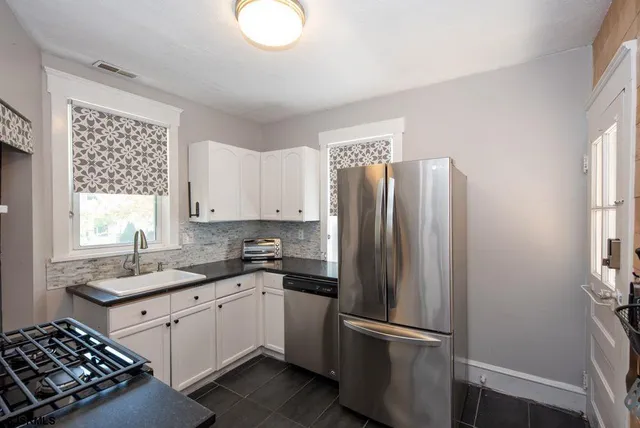 a kitchen with stainless steel appliances granite countertop a refrigerator sink and cabinets