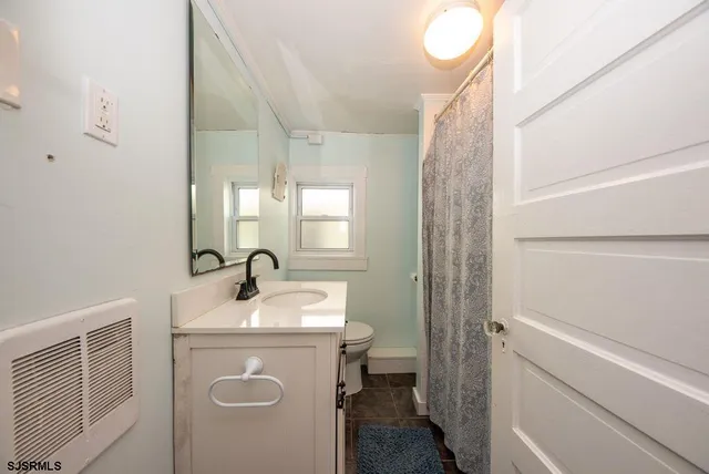 a bathroom with a sink a toilet and mirror