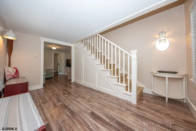 a view of a hallway with wooden floor and staircase