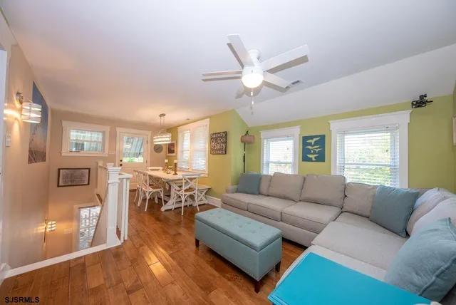 a living room with furniture and wooden floors