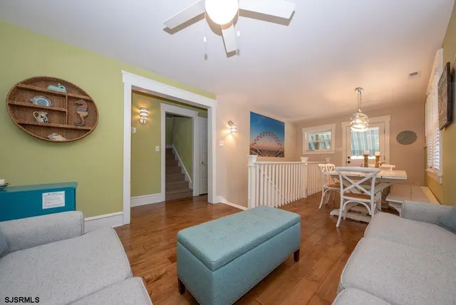 a living room with furniture a table and wooden floor